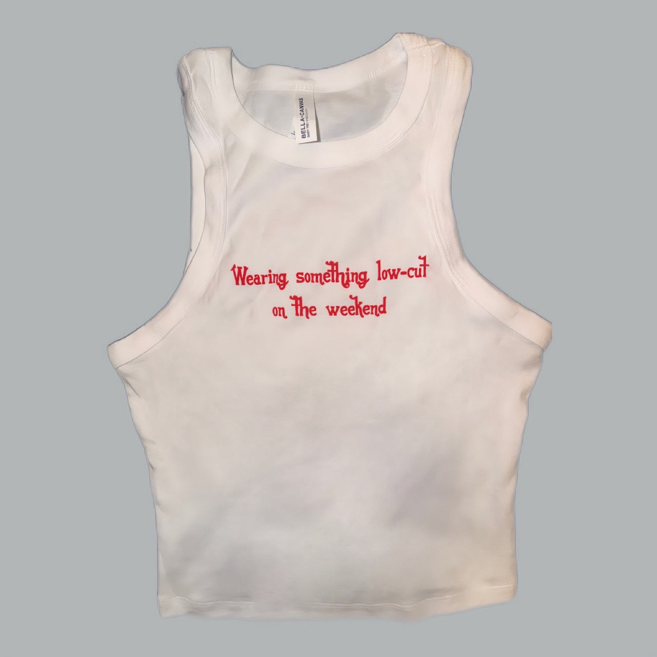 White Bella Canvas crop tank top with red embroidered text reading "Wearing something low-cut on the weekend" — Shaylen Lee Carroll official merch Nashville